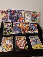 All twelve bagged and boarded Superman comic books displayed on table