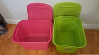 Green and pink tote bins open showing interiors and lids