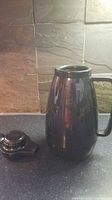 full view of black plastic thermos pitcher with lid beside