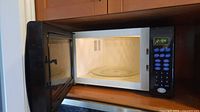 Microwave with door open showing interior and glass turntable