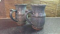 Two blue-green speckled ceramic mugs standing