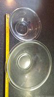Overhead view of both Pyrex bowls beside measuring tape