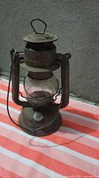 Lantern front view showing Beacon branding on cap, rust, glass globe
