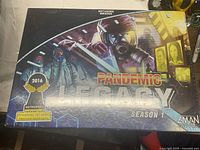 Front of sealed Pandemic Legacy Season 1 board game box with shrink wrap intact and award nomination sticker