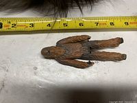 Figure face-up alongside measuring tape showing size