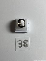 Gemstone in box, top view showing overall cut and colour with lot number 38 slip