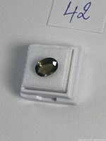 Top view of oval green tourmaline in gemstone box