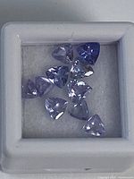 Close-up of nine trillion-cut tanzanite stones in display box