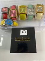 Six colored-strap watches on holders with black Joan Rivers box