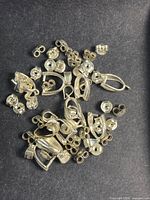 pile of silver leverbacks and butterfly backs on dark background