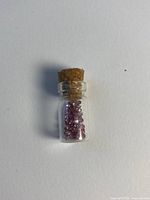 Vial with pink sapphires front view