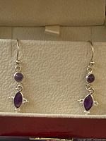 both earrings displayed in open jewelry box interior view