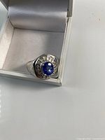 ring in box showing sapphire centre and halo