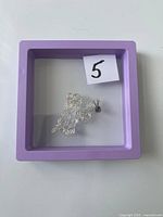 Necklace coiled inside purple display frame