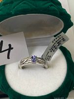 Ring in open box showing tanzanite stone and band design