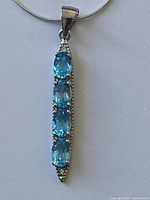 Close view of pendant showing four oval blue topaz stones in silver setting