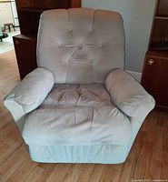 Front view of beige velvet electric recliner chair, showing tufted back, padded arms and skirted base