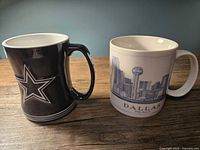 Front view of both mugs showing Dallas Cowboys star and Dallas skyline graphics