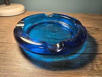 Top view showing round blue glass ashtray and four rests