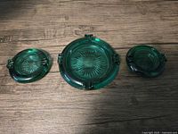 Top view of three emerald green ashtrays showing size difference