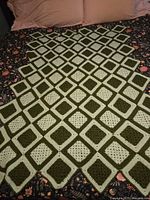 Whole throw laid out on bed showing overall diamond pattern and color contrast