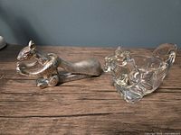 Metal squirrel nutcracker and glass squirrel tealight holder on wood surface