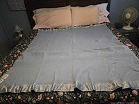 Light blue wool blanket spread on bed showing full size and satin trim
