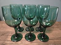 Front view of six forest green wine glasses