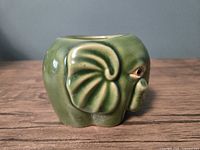 Left side view of green ceramic elephant planter
