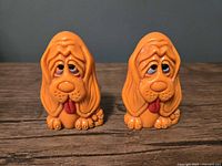Front view of both orange hound dog shakers showing overall design and condition