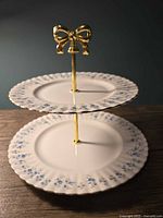 Front view of assembled two-tier dessert stand showing both plates and bow handle