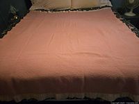 Full view of pink wool blanket spread on bed