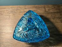 Top view of sky blue triangular cut glass dish with lid