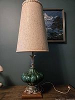 Full view of lamp showing shade, ceramic body, metal base, and cord
