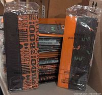 Stacks of sealed Halloween tissue paper packages showing both designs