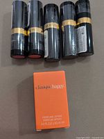 Five sealed Revlon lipsticks with Clinique Happy perfume box