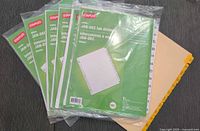 All seven divider sets, six sealed white Staples packages and one beige set
