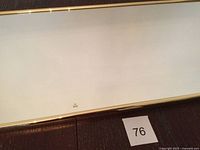 Front view of the rectangular brass-framed mirror