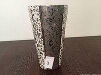 Front view of floral patterned metal vase