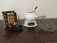 Overall view of fondue set, chicken roaster, wire basket and box