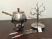 overview of fondue pot on stand, forks, and metal tree display