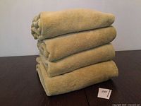 Stack of four light green towels on table