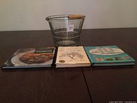 Glass bucket and three cookbooks on table