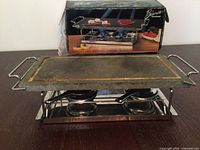 Stone grill assembled on table showing slab, frame and burners