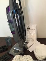 Upright vacuum/steam mop with accessories and manual