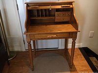 Desk with tambour open showing interior slots and drawers