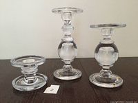 Three clear glass candle holders on table