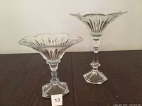 Both clear glass pedestal dishes side by side on table