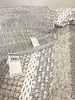 Close view showing woven textures, color bands and fabric tags