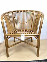 front view of rattan club chair showing slat design and stretcher